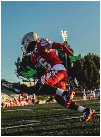 A football player wearing a blue and red jersey. Description generated by AI