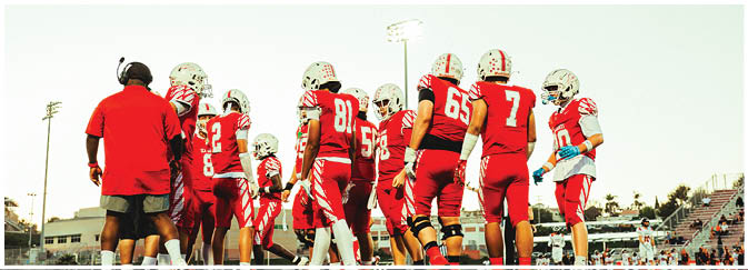 A football game is taking place on a field with players wearing blue and white uniforms. Description generated by AI
