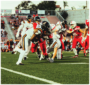 A football game is taking place with a group of men on the field. Description generated by AI