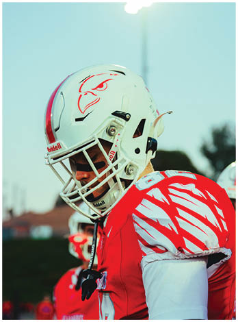 A football player wearing a blue and red jersey. Description generated by AI