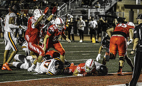 Two men wearing football uniforms are hugging each other on a field. AI generated content