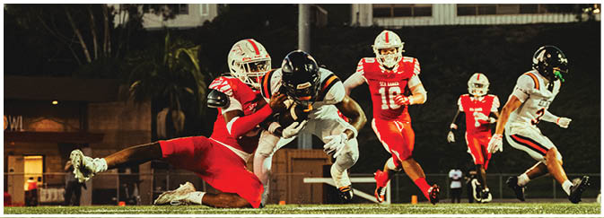 A football game is taking place on a field with players wearing blue and white uniforms. Description generated by AI