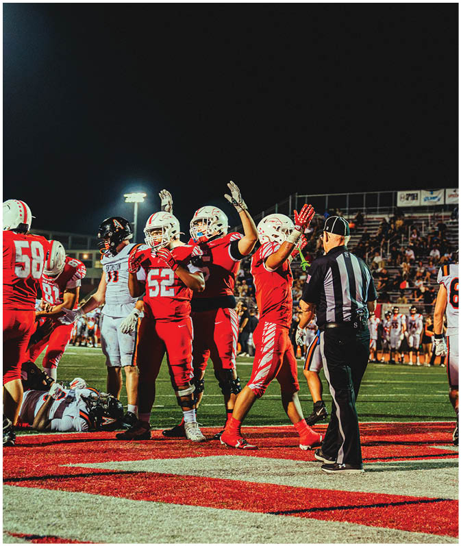 A group of football players on a field. Description generated by AI