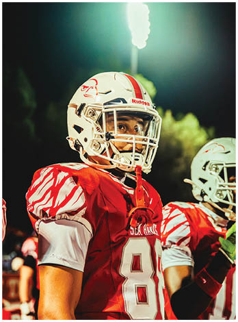 A football player wearing a blue and red jersey. Description generated by AI
