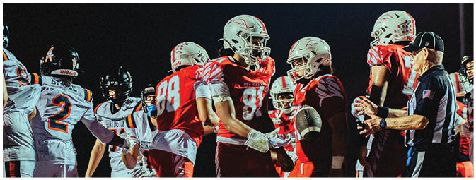 A group of football players on a field. Description generated by AI