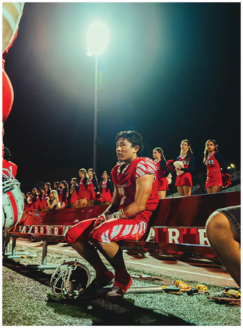 A football player wearing a blue and red jersey. Description generated by AI