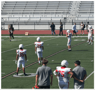A group of football players on a field. Description generated by AI