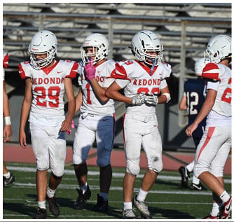 A group of football players on a field. Description generated by AI