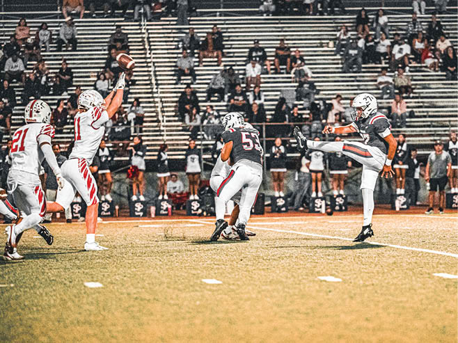 A group of football players in black and white uniforms are on the field. AI generated content