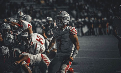 Two men wearing football uniforms are hugging each other on a field. AI generated content