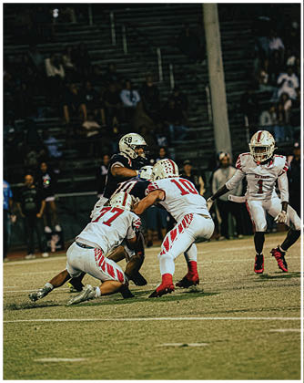 A football game is taking place with a group of men on the field. Description generated by AI