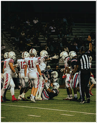 A football game is taking place with a group of men on the field. Description generated by AI
