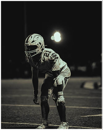 A football game is taking place with a group of men on the field. Description generated by AI