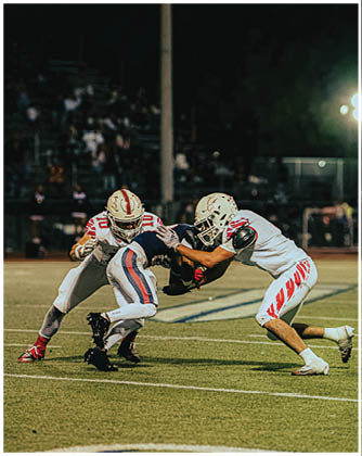 A football game is taking place with a group of men on the field. Description generated by AI