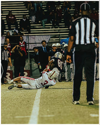 A football game is taking place with a group of men on the field. Description generated by AI