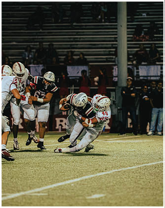 A football game is taking place with a group of men on the field. Description generated by AI