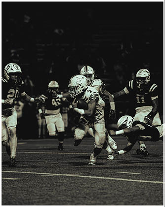 A football game is taking place with a group of men on the field. Description generated by AI
