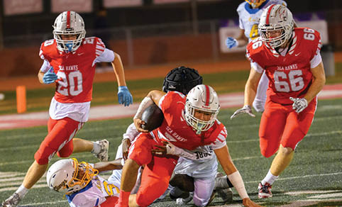 Two men wearing football uniforms are hugging each other on a field. AI generated content