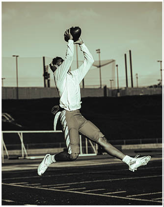 A football game is taking place with a group of men on the field. Description generated by AI