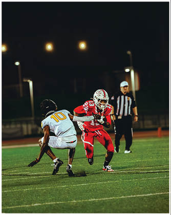 A football game is taking place with a group of men on the field. Description generated by AI
