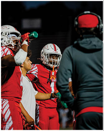 A football game is taking place with a group of men on the field. Description generated by AI