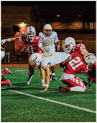 A football game is taking place with a group of men on the field. Description generated by AI