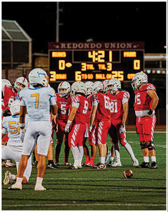 A football game is taking place with a group of men on the field. Description generated by AI