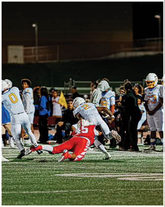 A football game is taking place with a group of men on the field. Description generated by AI