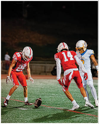 A football game is taking place with a group of men on the field. Description generated by AI