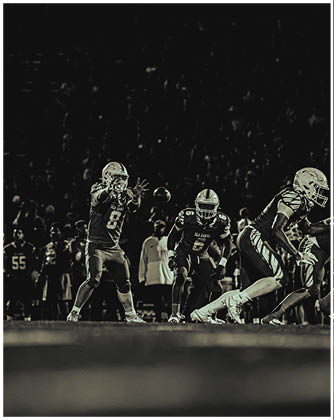 A football game is taking place with a group of men on the field. Description generated by AI