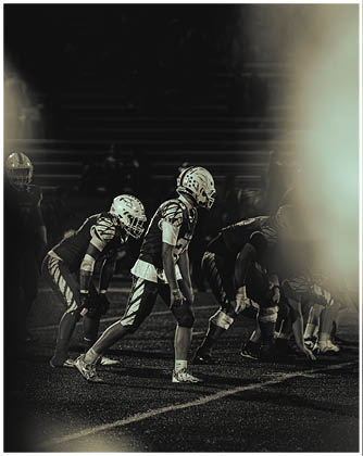 A football game is taking place with a group of men on the field. Description generated by AI