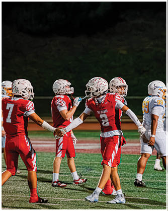 A football game is taking place with a group of men on the field. Description generated by AI