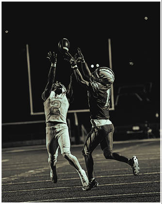 A football game is taking place with a group of men on the field. Description generated by AI
