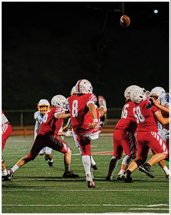A football game is taking place with a group of men on the field. Description generated by AI