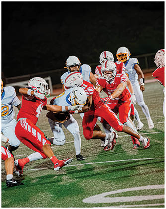 A football game is taking place with a group of men on the field. Description generated by AI