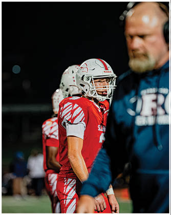 A football game is taking place with a group of men on the field. Description generated by AI