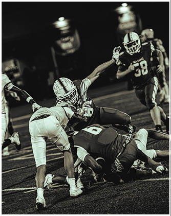 A football game is taking place with a group of men on the field. Description generated by AI