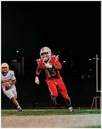 A football game is taking place with a group of men on the field. Description generated by AI