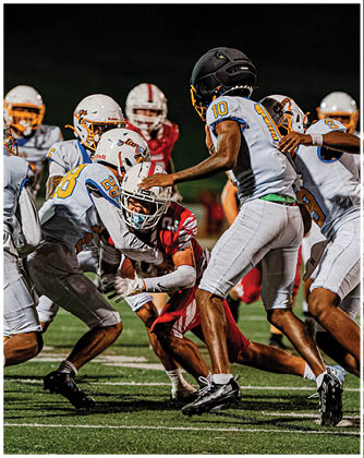 A football game is taking place with a group of men on the field. Description generated by AI