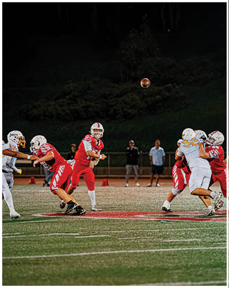 A football game is taking place with a group of men on the field. Description generated by AI