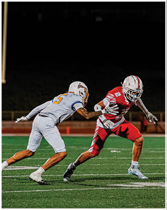A football game is taking place with a group of men on the field. Description generated by AI