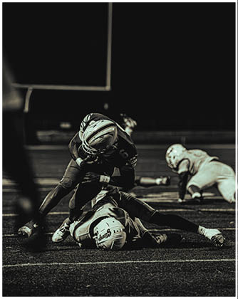 A football game is taking place with a group of men on the field. Description generated by AI