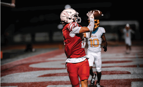 Two men wearing football uniforms are hugging each other on a field. AI generated content