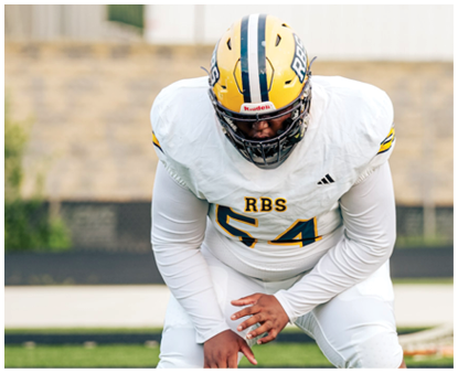 A person wearing a yellow helmet and white football uniform with the number 54 is crouched on a football field. Description generated by AI