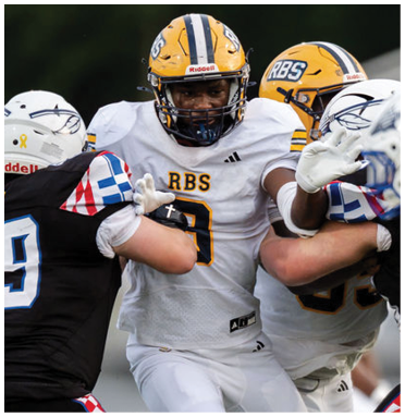 People wearing football uniforms are engaged in a close physical play on the field. Description generated by AI