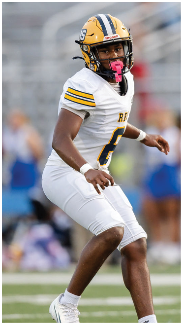 A person wearing a yellow and black football helmet and white uniform with the number 6 is poised in an athletic stance on a football field. Description generated by AI
