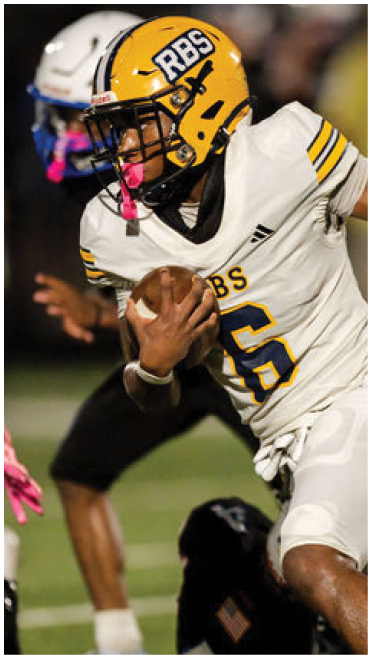 Two people in white football uniforms with yellow helmets are actively playing on a field, with one holding the ball and running while the other appears to be moving to assist. Description generated by AI