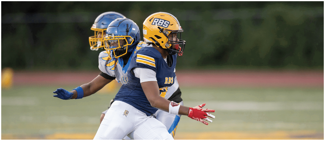 A person wearing a blue and yellow football uniform with the number 57 is running on a field with other players blurred in the background. Description generated by AI