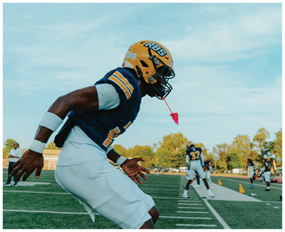 A person wearing a yellow helmet with the letters RBS on it is visible against a blue sky with light clouds. Description generated by AI