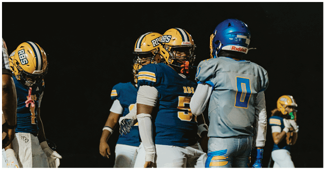 Three people wearing football helmets are visible at the bottom of the image against a dark background. Description generated by AI